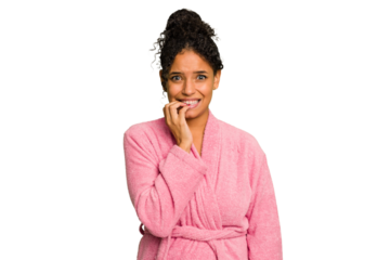 Young brazilian woman wearing a pink bathrobe isolated biting fingernails, nervous and very anxious.
