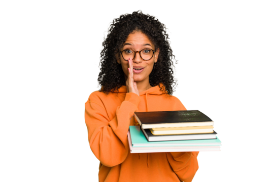 Young student woman holding a pile of books isolated is saying a secret hot braking news and looking aside