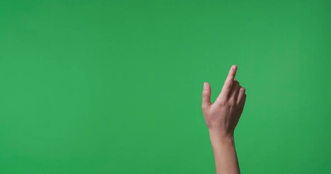 Female hand swiping and clicking  to virtual screen on chroma key background, closeup