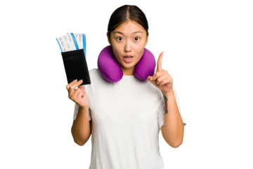 Young asian woman with inflatable travel pillow on her neck holding passport isolated having an idea, inspiration concept.