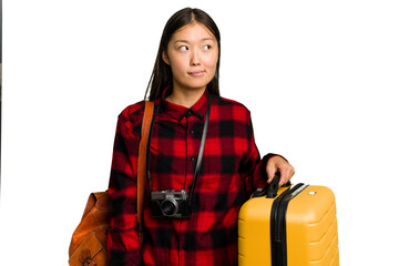 Traveler asian woman holding a suitcase isolated confused, feels doubtful and unsure.