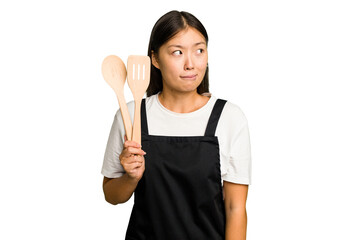 Young asian cook woman isolated confused, feels doubtful and unsure.