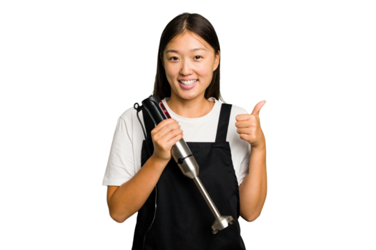 Young asian cook woman holding a blender isolated smiling and raising thumb up