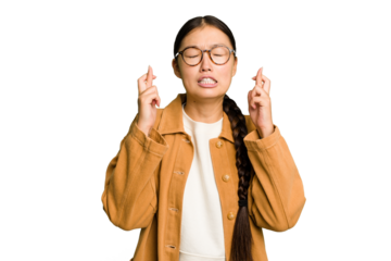 Young Asian woman isolated crossing fingers for having luck