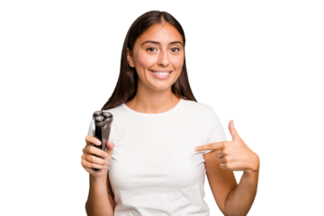 Young caucasian woman holding a razor isolated person pointing by hand to a shirt copy space, proud and confident