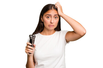 Young caucasian woman holding a razor isolated being shocked, she has remembered important meeting.