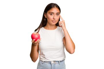 Young caucasian woman holding a red apple isolated pointing temple with finger, thinking, focused on a task.