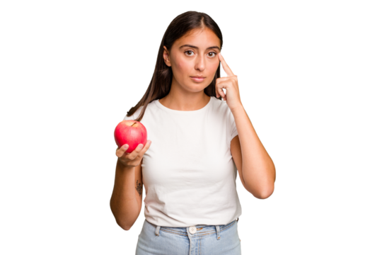 Young caucasian woman holding a red apple isolated pointing temple with finger, thinking, focused on a task.