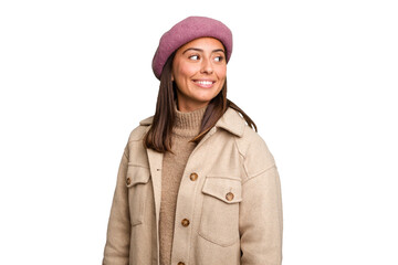 Young caucasian woman wearing winter jacket isolated looks aside smiling, cheerful and pleasant.