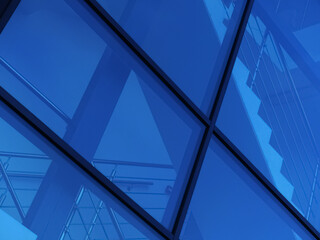 Stairs behind the blue glass panels of the facade of a modern building