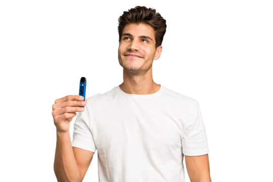 Young caucasian man holding an electronic cigarette isolated dreaming of achieving goals and purposes