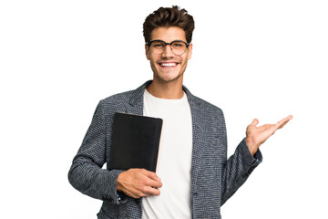 Young teacher caucasian man holding a book isolated showing a copy space on a palm and holding...