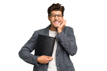 Young teacher caucasian man holding a book isolated covering ears with hands.