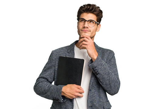 Young teacher caucasian man holding a book isolated looking sideways with doubtful and skeptical expression.