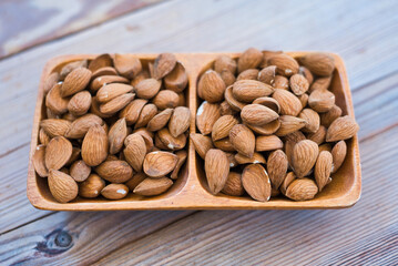 Almonds nuts on wooden bowl on table background , top view  almond