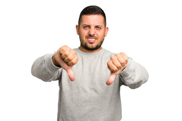 Young caucasian man isolated showing thumb down and expressing dislike.