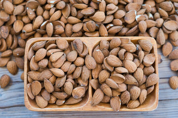 Almonds nuts on wooden bowl on table background , top view  almond