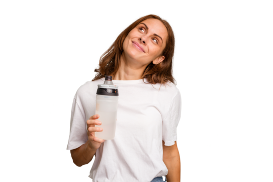 Young caucasian sport woman holding a bottle of water isolated dreaming of achieving goals and purposes