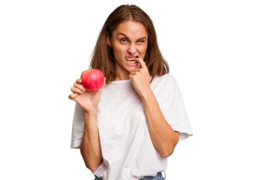 Young caucasian woman holding a red apple isolated relaxed thinking about something looking at a copy space.