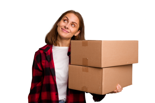 Young caucasian woman moving while picking up a box full of things isolated dreaming of achieving goals and purposes