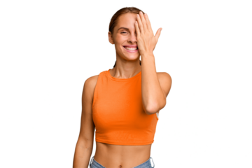 Young caucasian woman isolated having fun covering half of face with palm.