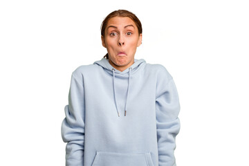 Young caucasian woman isolated shrugs shoulders and open eyes confused.