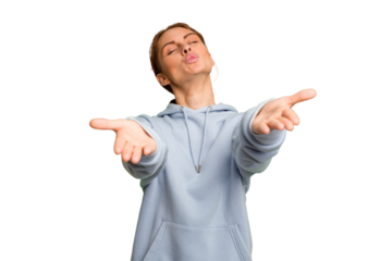 Young caucasian woman isolated folding lips and holding palms to send air kiss.