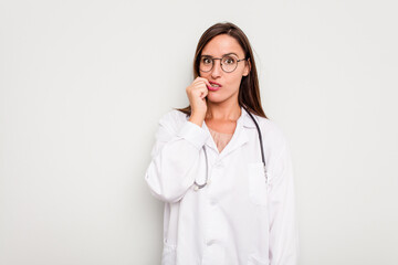 Young doctor woman isolated on white background biting fingernails, nervous and very anxious.