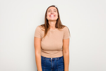 Young caucasian cute woman isolated on white background laughs and closes eyes, feels relaxed and happy.