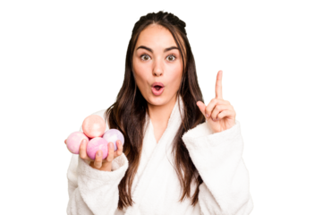Young caucasian woman holding aromatic balls for bathtub isolated on green chroma background having an idea, inspiration concept.