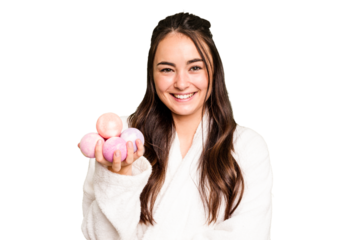 Young caucasian woman holding aromatic balls for bathtub isolated on green chroma background laughing and having fun.