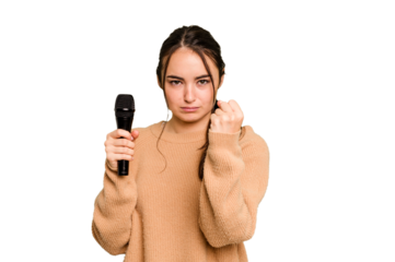 Young caucasian singer woman isolated on green chroma background showing fist to camera, aggressive facial expression.