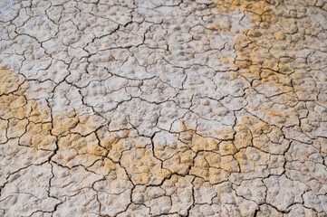 Cracked white-yellow clay. Hot climate in the desert.
