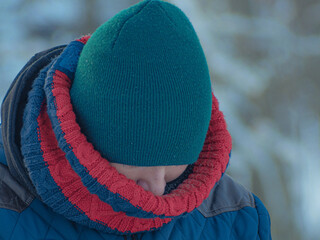A teenager dressed warmly in winter. Schoolboy in winter with scarf and hat. Soft focus on the face