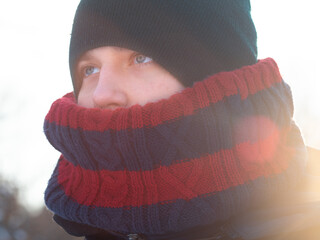 A teenager dressed warmly in winter. Schoolboy in winter with scarf and hat. Soft focus on the face
