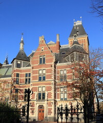 Obraz premium Amsterdam Rijksmuseum Building Exterior Detail with Bright Blue Sky and Autumn Tree, Netherlands