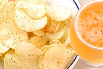 のり塩味のポテトチップスと、よく冷えたビールのグラス
