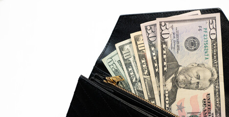 USD cash money in a big pile. Paper money in a black, leather wallet close up.  Cash of paper currency background, isolated on white background. 
