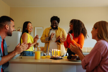 Diverse friends celebrate birthday at home.