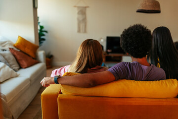 Diverse people watching tv indoors.