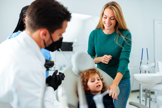 Mom comforting scared child at dentist.