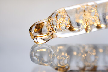 Pipettes with oil or serum with air bubbles on a gray background. Side view, close-up.