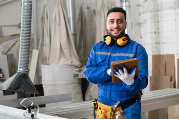 Arab carpenter in safety uniform work with tablet computer at wood factory