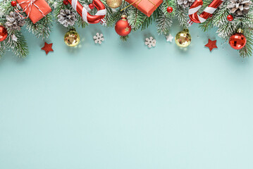 Christmas or Happy New Year composition made of fir tree, decorations and gift boxes on blue background. Flat lay