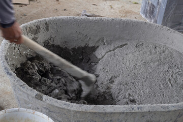 Mixer Cement with hoe in plastic bucket in construction site.