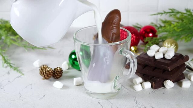 Making winter hot cocoa drink, preparation funny Christmas hot chocolate with milk and chocolate Santa figure, christmas diy lifehack recipe