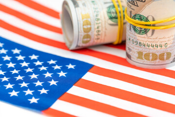 Rolls of money dollars on USA American flag as background. Finance and economy concepts.
