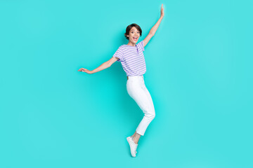 Fototapeta na wymiar Full length photo of adorable funny lady wear violet t-shirt having fun dancing isolated turquoise color background