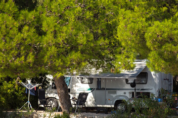 Reisemobil auf dem Campingplatz unter Bäumen