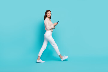 Fototapeta na wymiar Full length photo of positive lady manager stylish clothes hurry work use gms map navigation empty space isolated on cyan color background